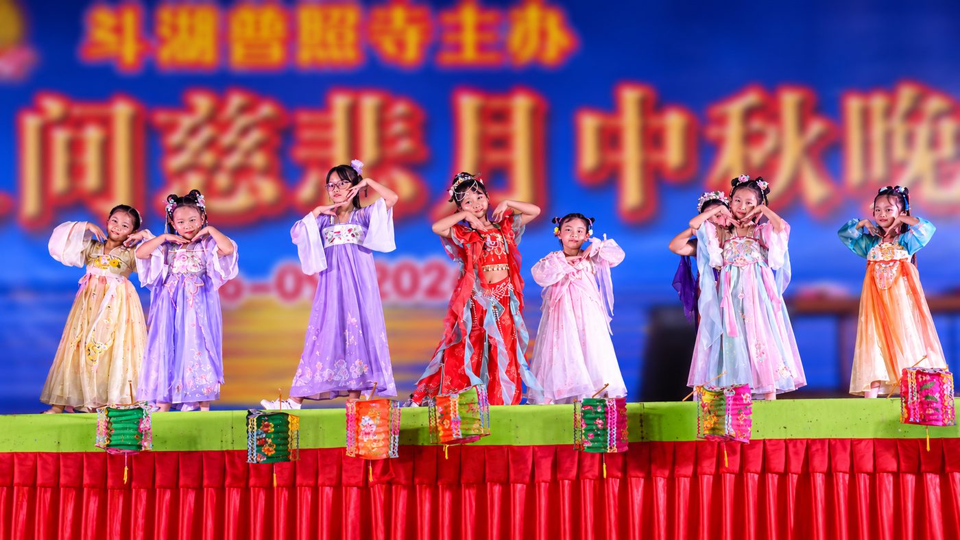 Little girls in traditional costume present their lanterns