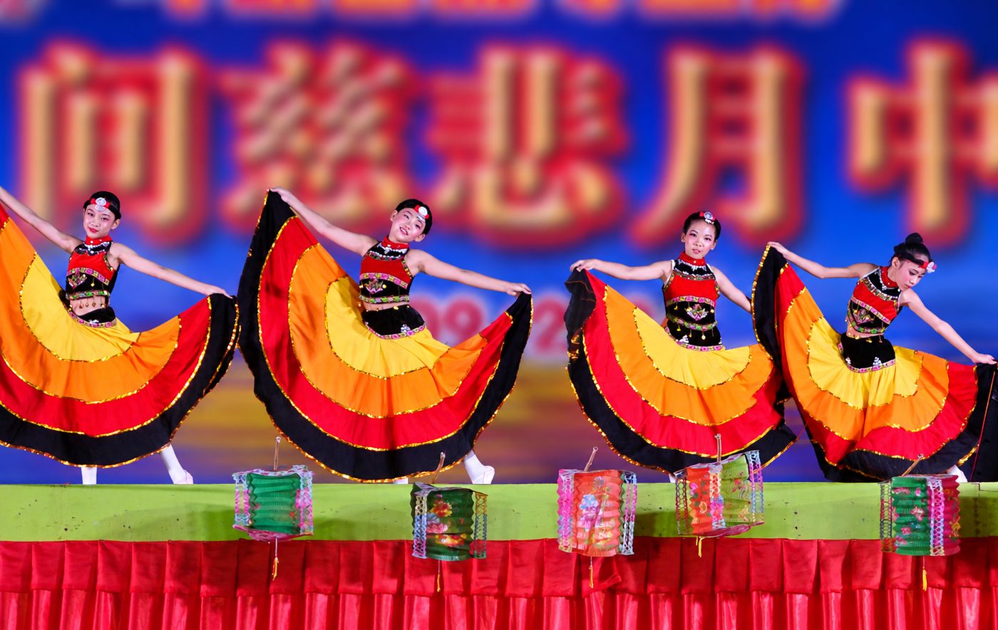 Young dancers in swirling skirts at the 2026 Compassionate Moon gathering
